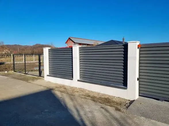 Gard metalic antracit cu panouri moderne și stâlpi albi